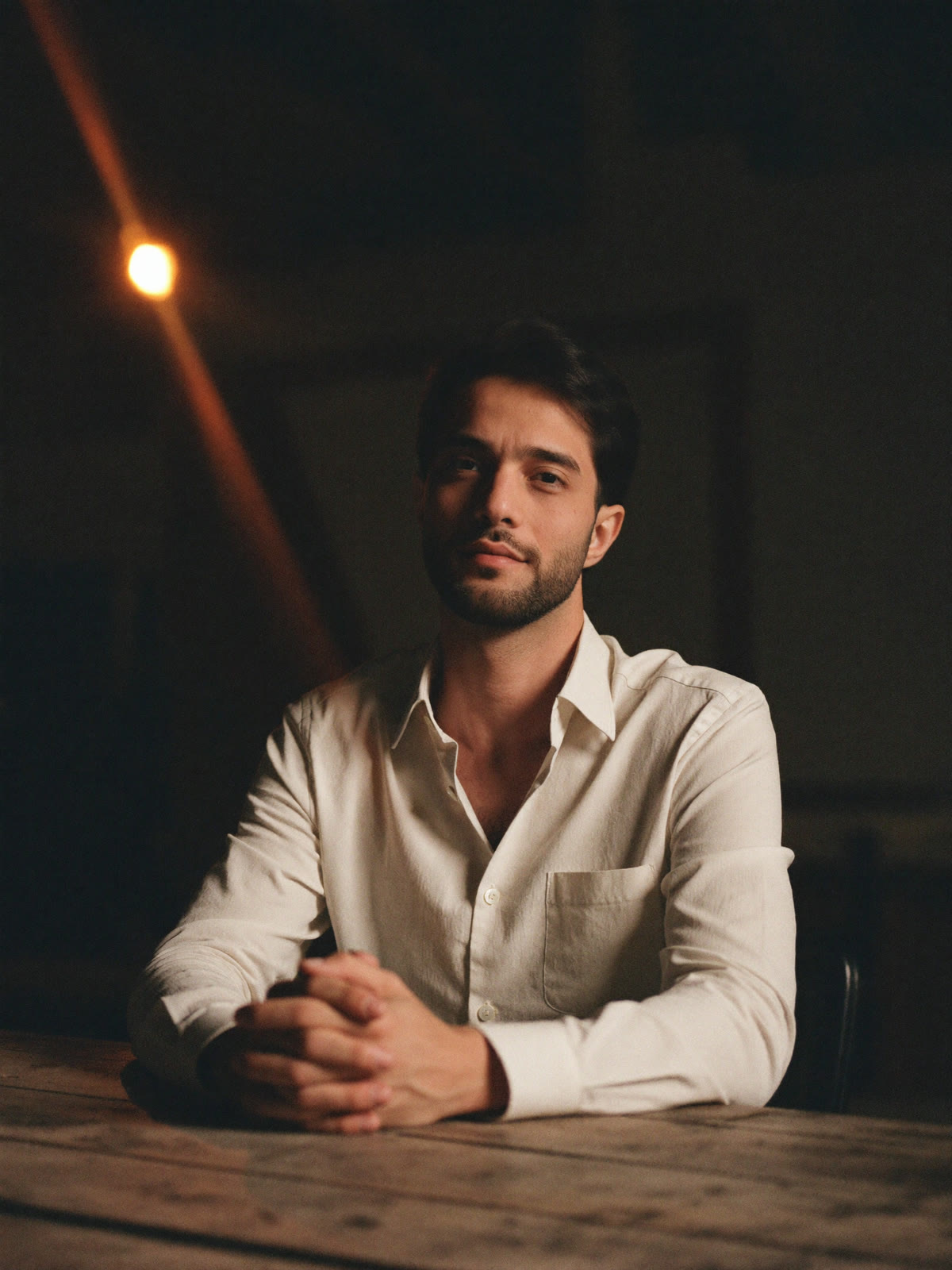 Ali Al-Khafaji — studio portrait, seated at the worktable